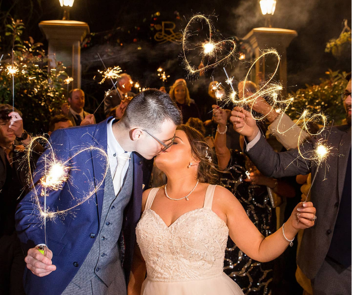 Wedding couple kissing in front of The Rose Hotel